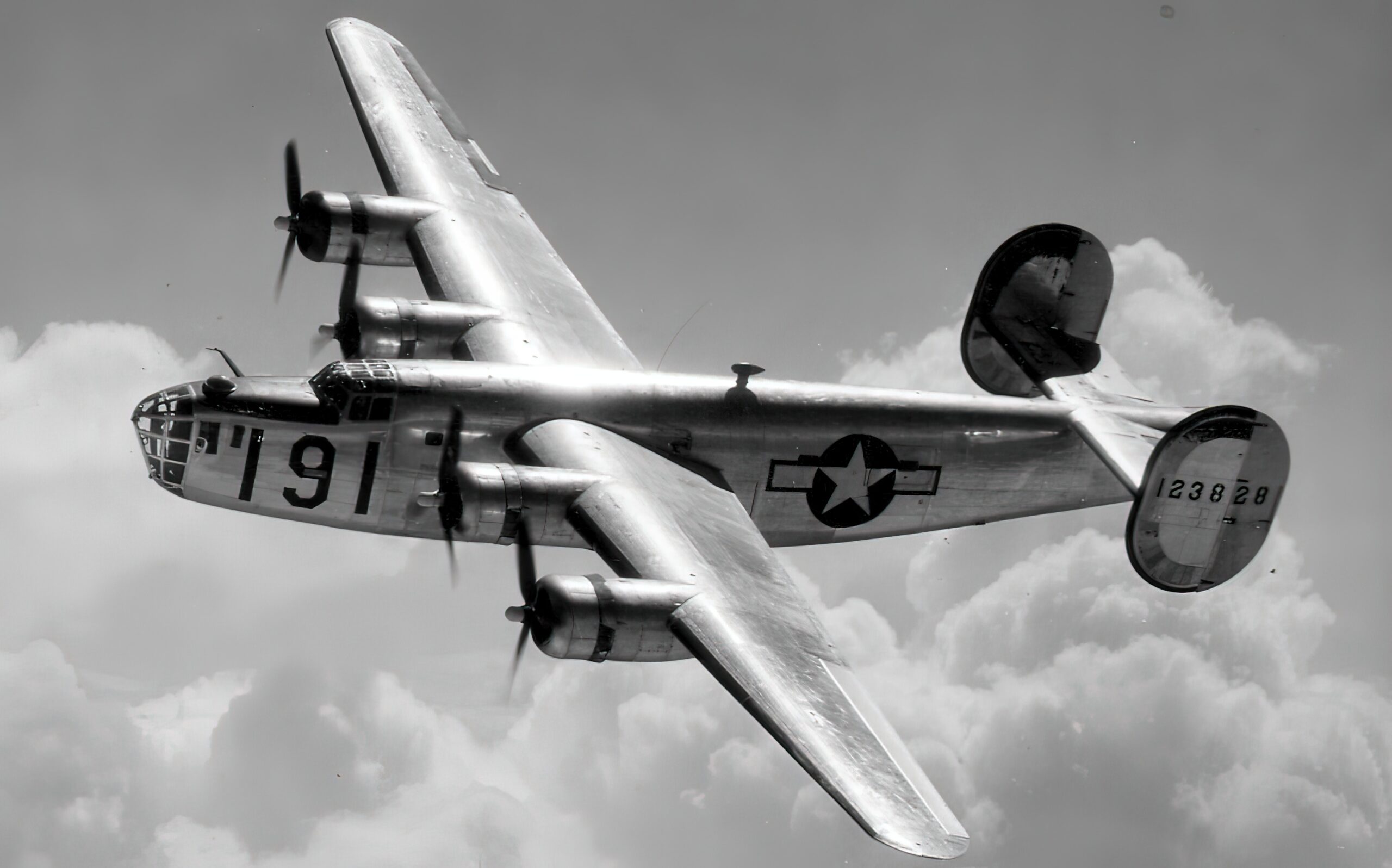 A Consolidated B-24 Liberator from Maxwell Field, Alabama, four engine pilot school, glistens in the sun as it makes a turn at high altitude in the clouds