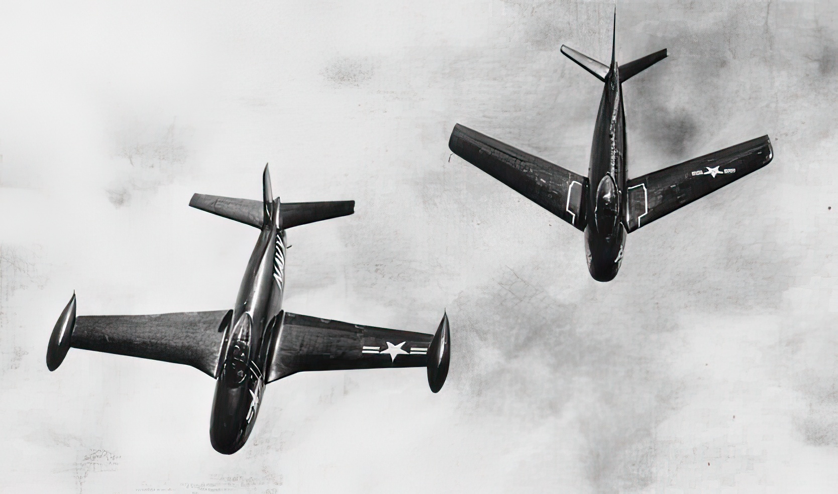 A straight-winged North American FJ-1 flying next to a swept-wing FJ-2 in 1952