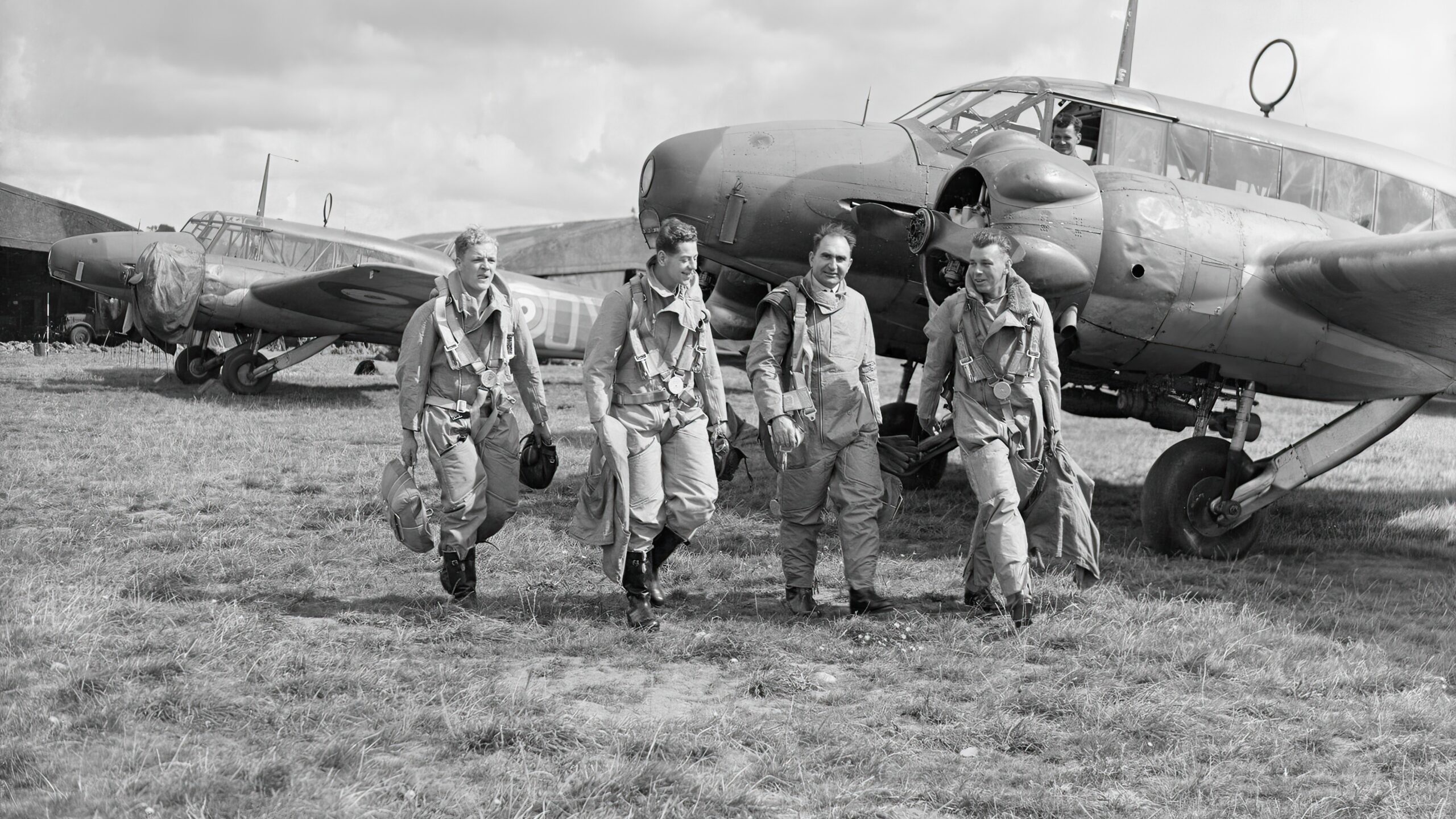 Pilots of No. 320 (Dutch), or 321 (Dutch) Squadron RAF walk to their Avro Anson Mark Is at Carew Cheriton, Pembrokeshire