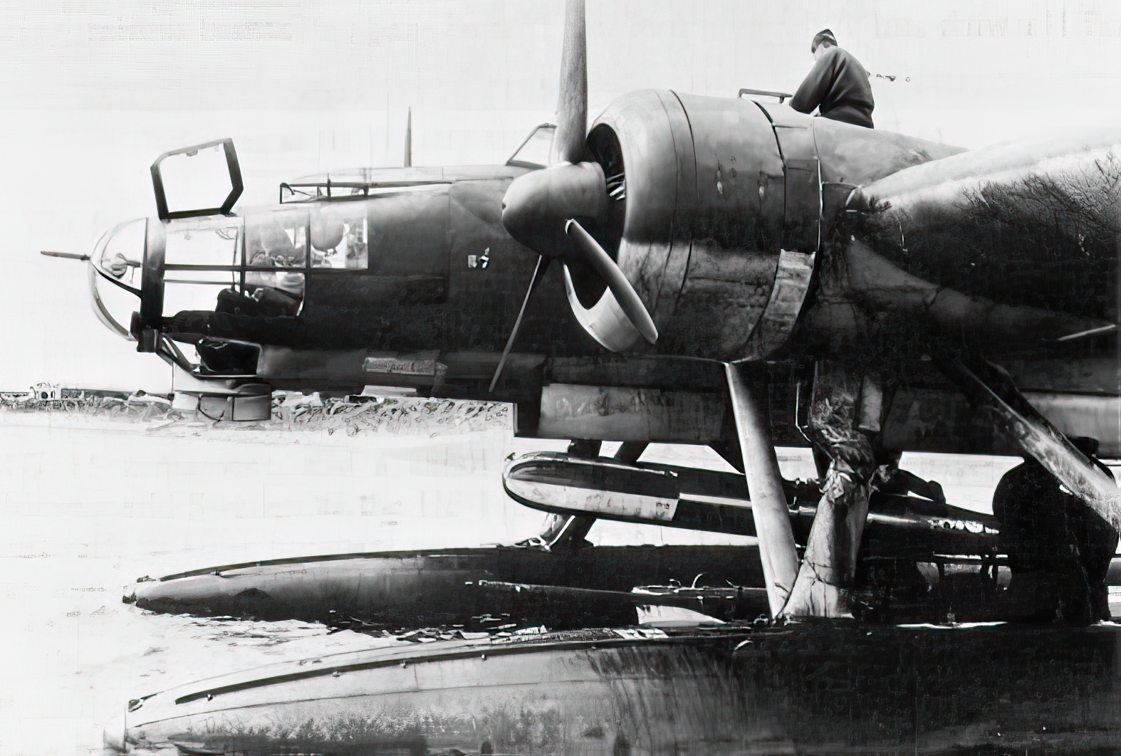 A torpedo is loaded on a German Heinkel He 115 seaplane 1940
