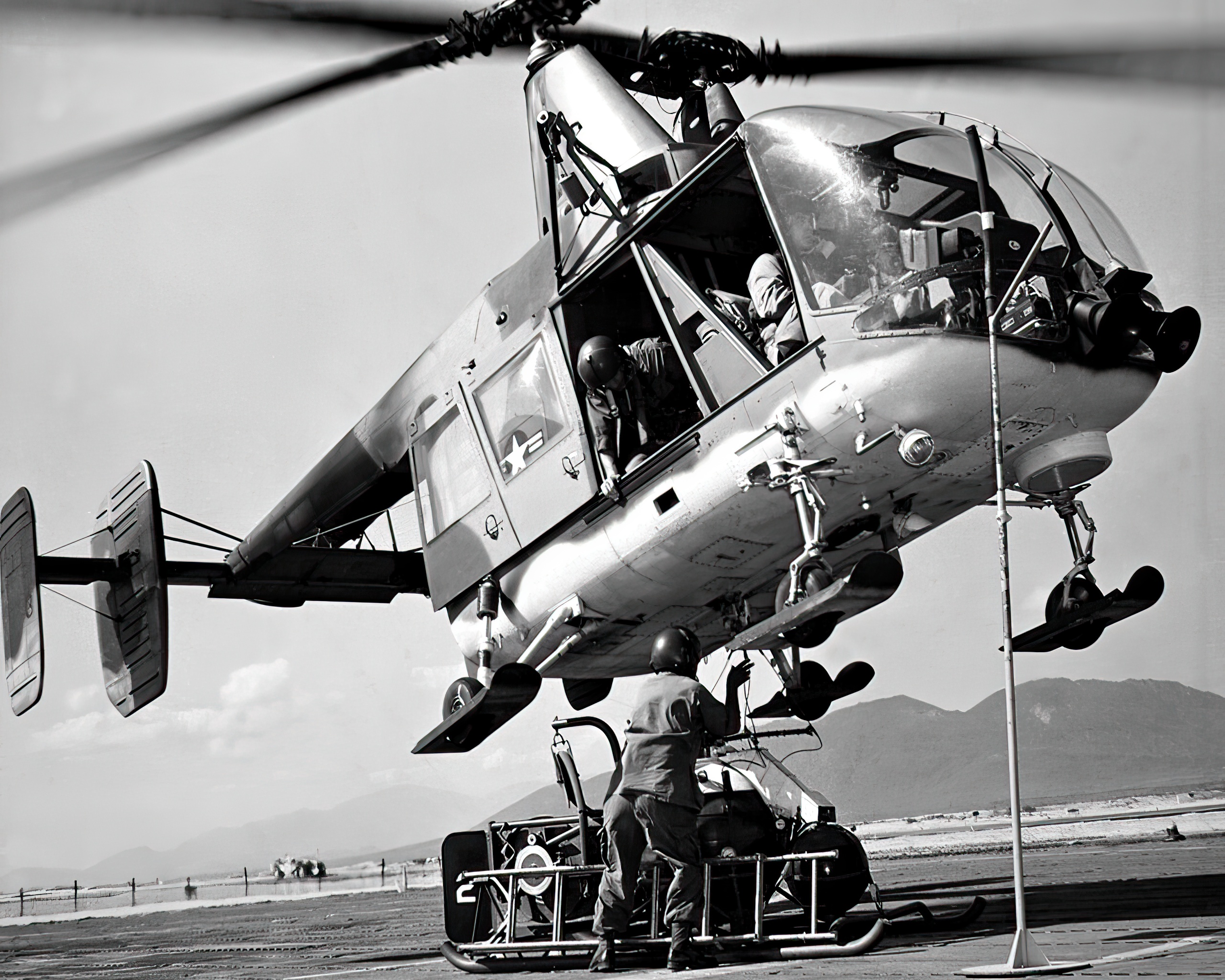 U.S. Air Force fire protection specialist hooks fire fighting equipment on a Kaman HH-43B Huskie helicopter. The crew was assigned to Detachment 8, 38th Aerospace Rescue and Recovery Squadron, Cam Ranh Bay Air Base, Vietnam