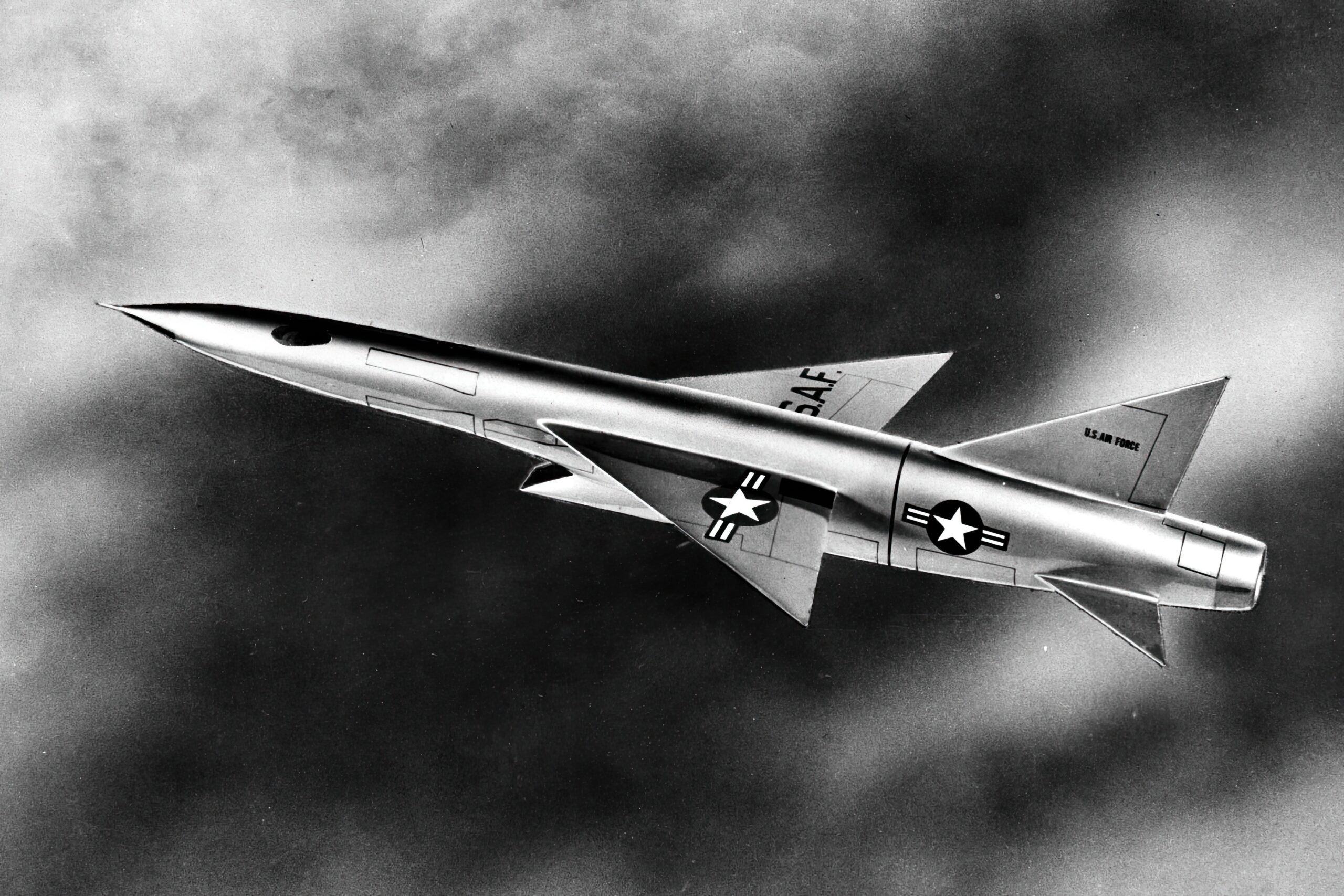 XF-103 Fighter. The dark oval near the nose is one of the two side-view windows. The outlines of the weapons bays can be seen just behind the cockpit area. The air-brakes can be seen at the rear, just in front of the jet nozzle. The line separating the "tiperons" from the rest of the wing is also visible.