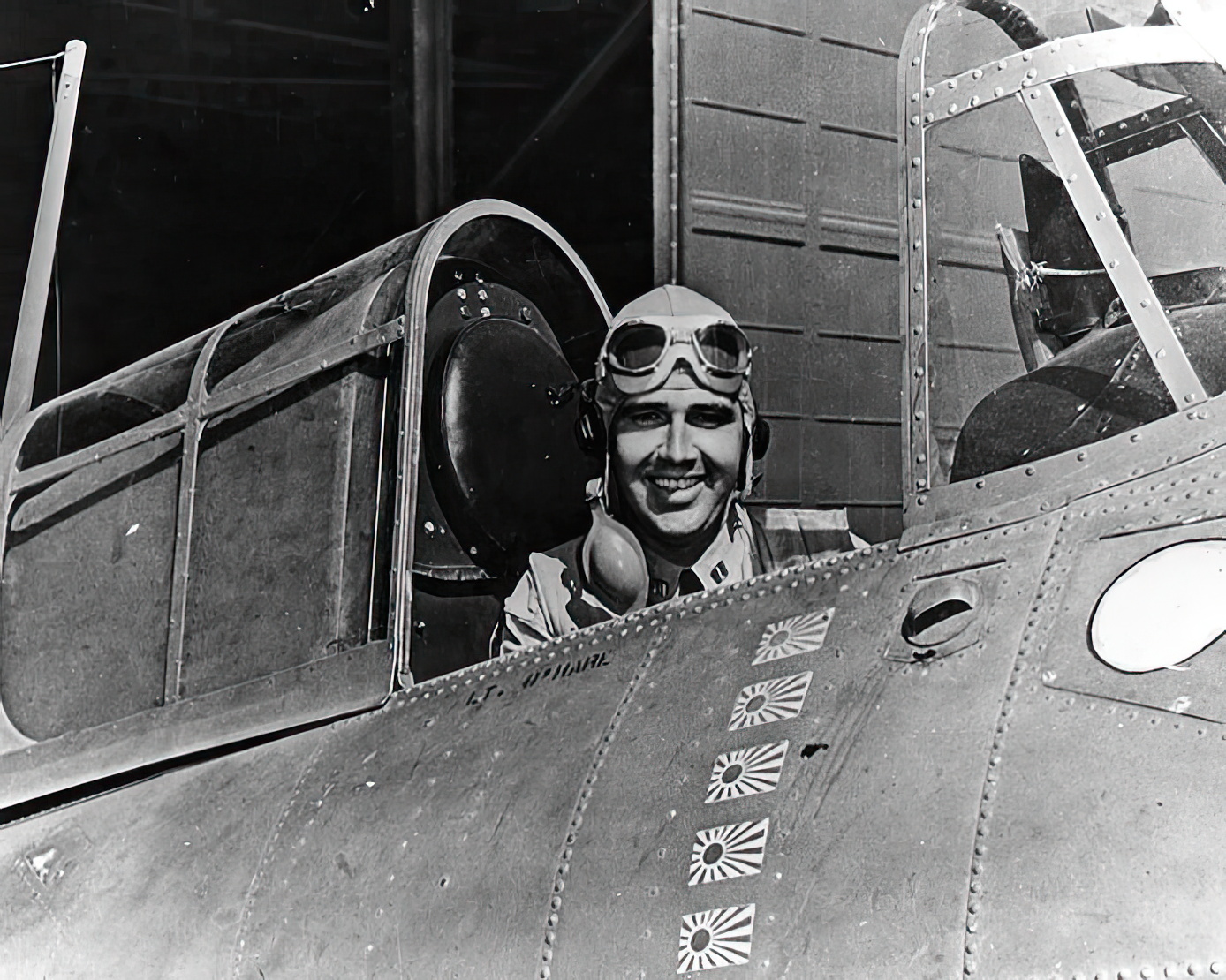 Lt. Butch O'Hare seated in the cockpit of his Grumman F4F "Wildcat" fighter, circa spring 1942. The plane is marked with five Japanese flags, representing the five enemy bombers he was credited with shooting down