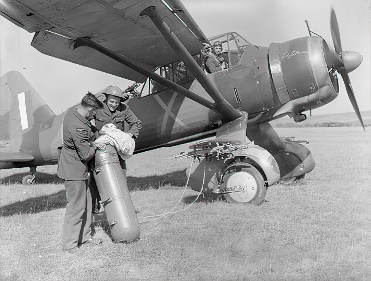 No. 22 (army Co-operation) Group, Royal Air Force, June-november 1940. Groundcrew pack a parachute into a supply dropper before fitting it to the stub winglets of a Westland Lysander Mark II of No. 225 Squadron RAF at Tilshead, Wiltshire