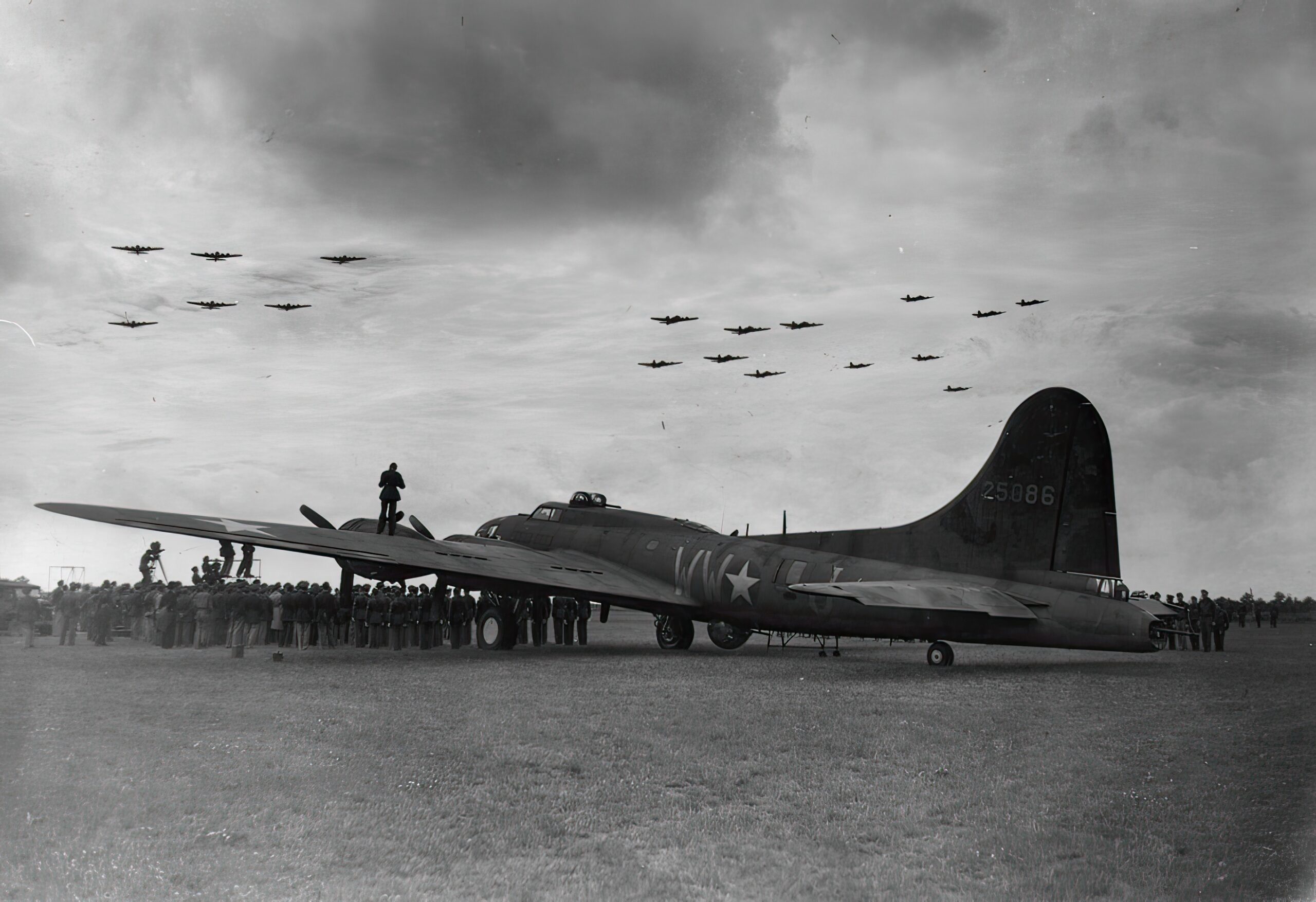 B-17 Flying Fortresses of the 306th Bomb Group fly in formation over another B-17 (WW-J, serial number 42-5086) during a medal ceremony for Staff Sergeant Maynard Smith. Passed for publication 16 Jul 1943