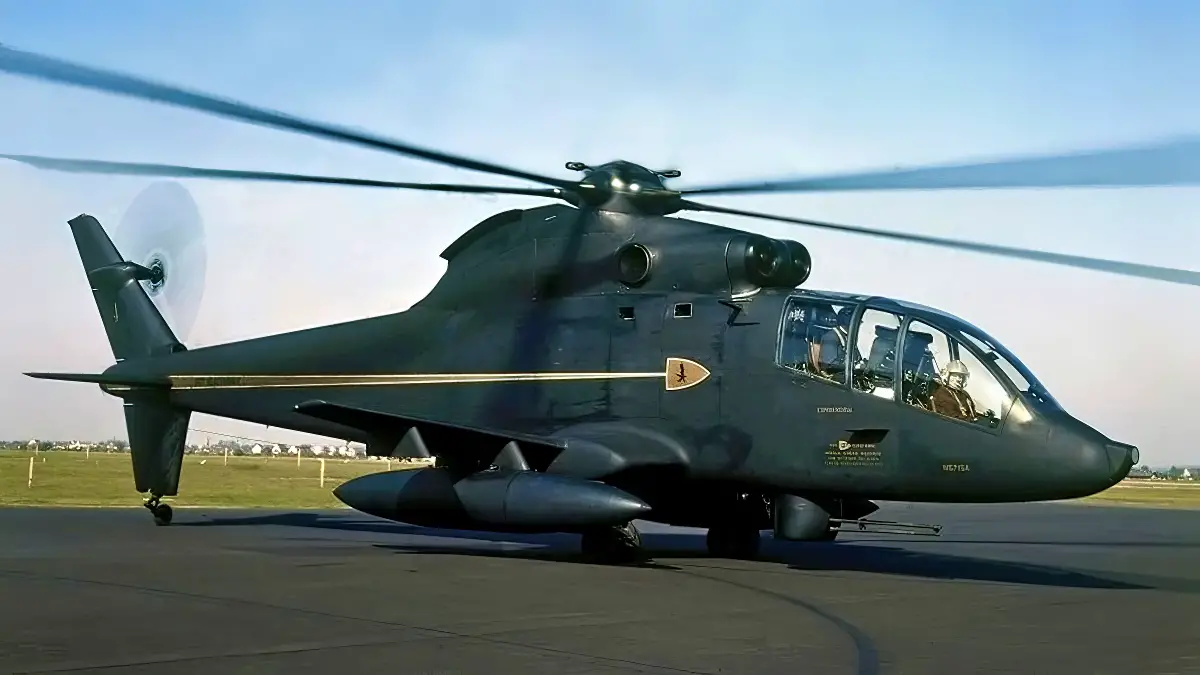 The S-67’s rudders can be seen in this image. One is on the upper fin below the tail rotor, and the other is on the lower fin. Pylons have been installed on the wings’ hardpoints, with drop tanks mounted to the inner stations. The turret is installed with a M197 three-barrel 20 mm cannon